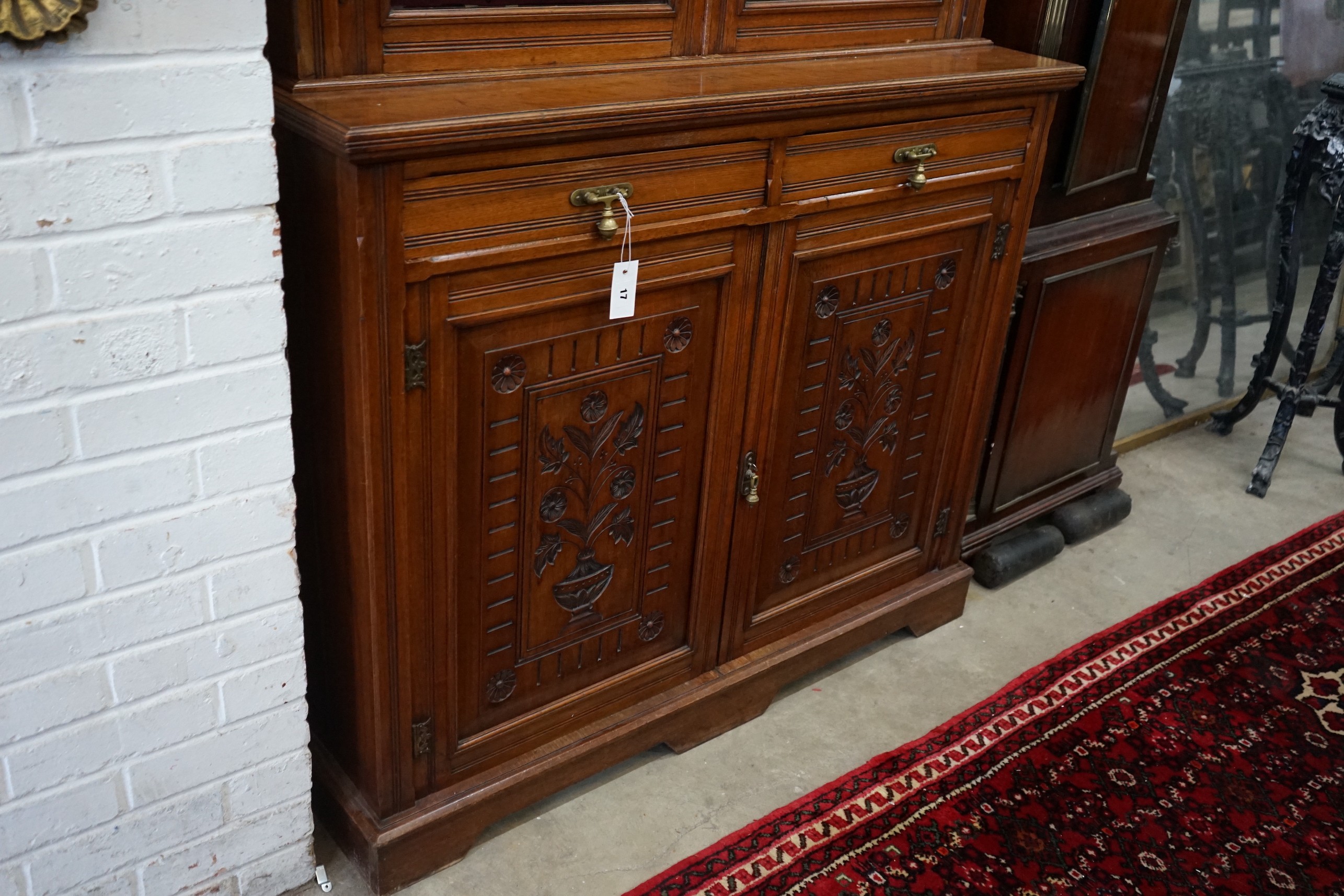 A late Victorian walnut bookcase cupboard, width 121cm, depth 48cm, height 236cm